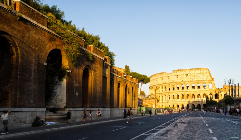 Colosseum in daylight sun, from the Via dei Fori Imperiali.