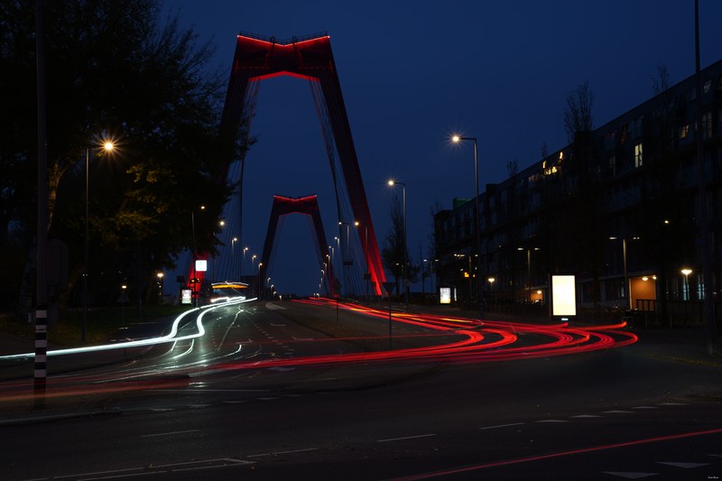Tail-light trails echoing the red columns of Willemsbrug, Rotterdam